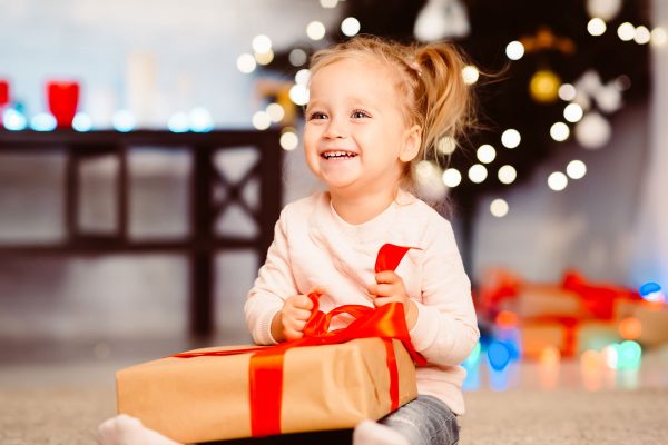 cute little girl with pigtails opens Christmas gift