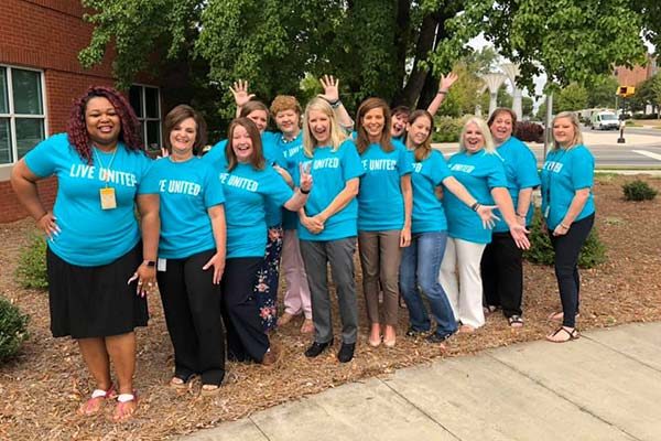 United Way Rock Hill South Carolina volunteers standing together outside in blue shirts.