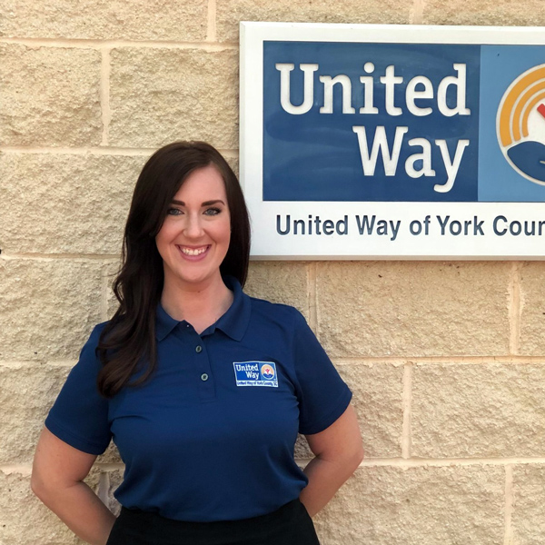 Mollie Rose standing in front of a United Way of York County, SC sign.