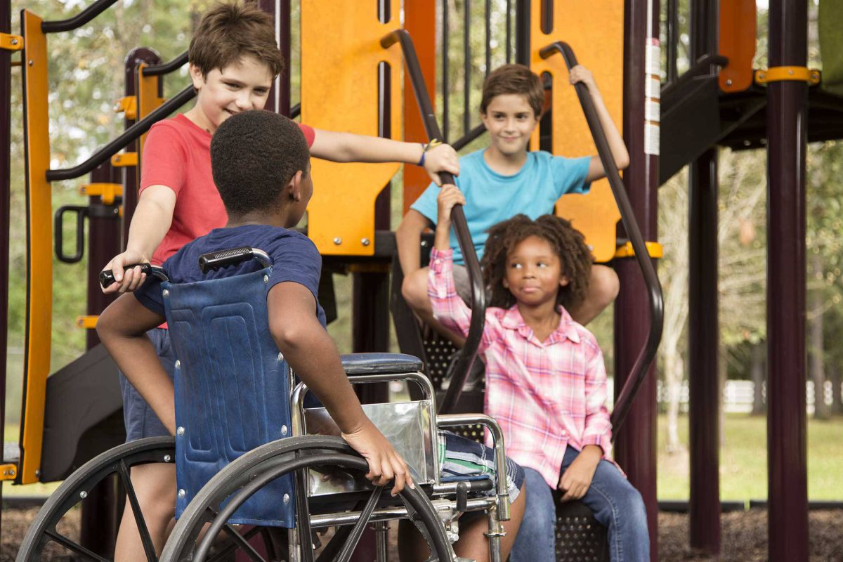 Group of young kids playing outside together on playground.