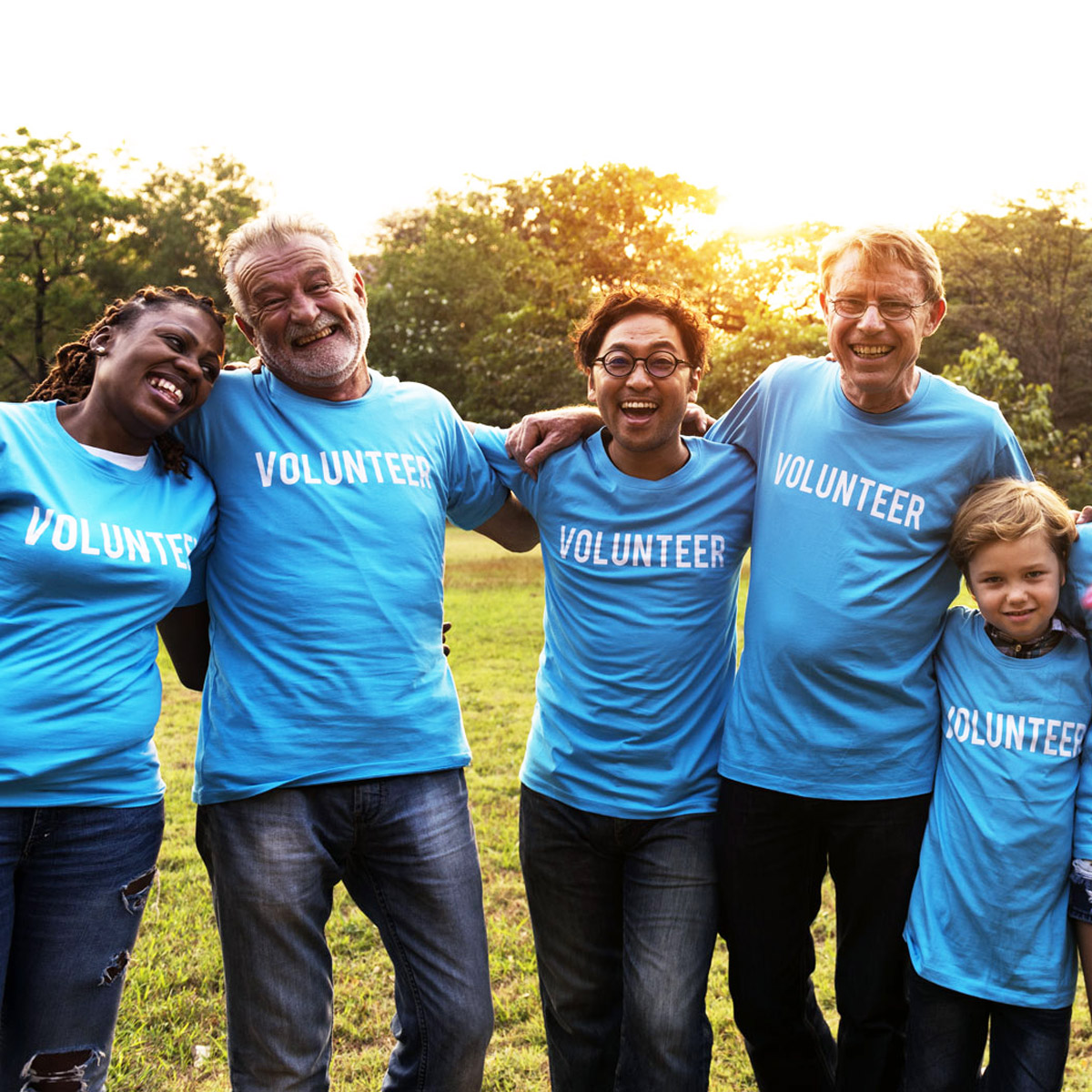 United Way volunteers in blue shirts smiling outside together.